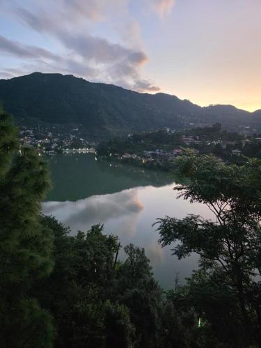 a view of a lake with trees and a city at Pi Palace in Bhīm Tāl