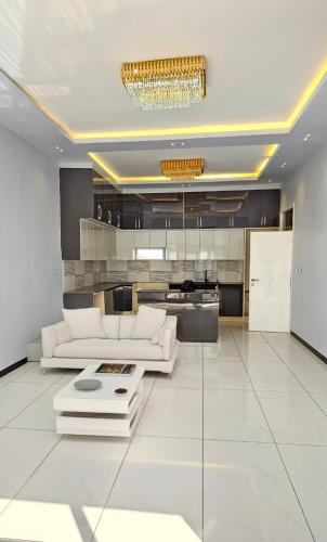 een woonkamer met een witte bank en een kroonluchter bij Private Villa in Addis Ababa