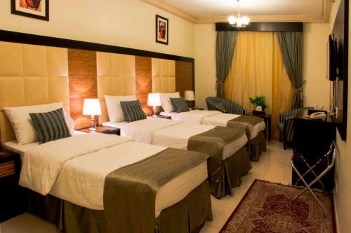 a hotel room with four beds in a room at Diyaralmashaer Al-Hadiyah Hotel in Makkah