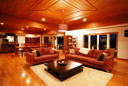 a living room with two couches and a coffee table at Puketotara Lodge in Kerikeri