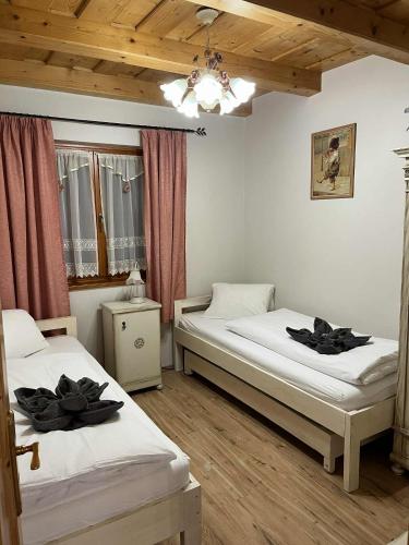 two twin beds in a room with wooden ceilings at Tölgyfa Apartman in Balatonkeresztúr