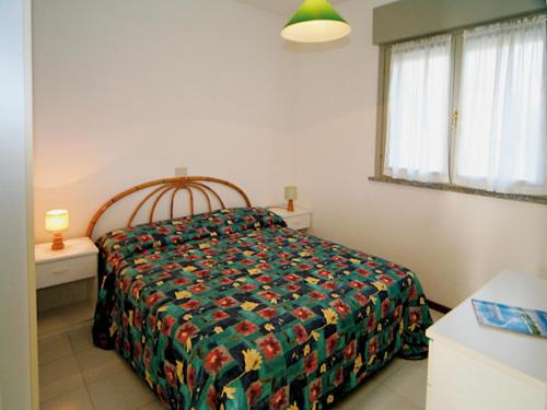 リニャーノ・サッビアドーロにあるVeraのベッドルーム1室(カラフルな掛け布団付きのベッド1台付)