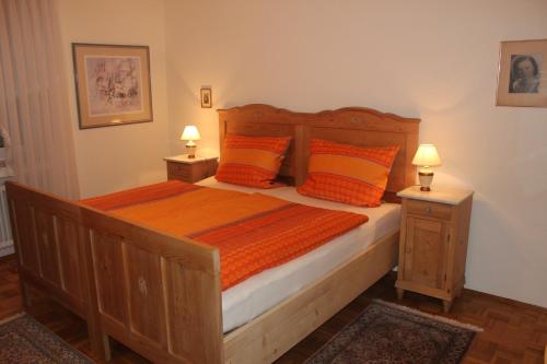 sypialnia z dużym drewnianym łóżkiem z pomarańczowymi poduszkami w obiekcie Ferienwohnung Waltraud w mieście Tieringen