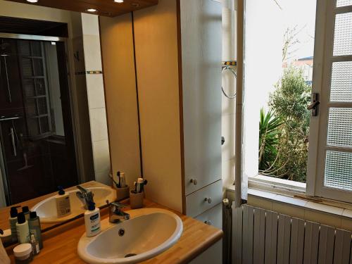 a bathroom with a sink and a mirror and a window at Villa Simone - 200m de la Plage in Les Sables-d'Olonne