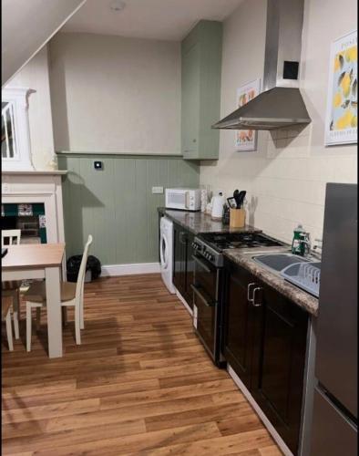 a kitchen with a sink and a stove top oven at Beautiful Countryside Cottage Alnwick in Alnwick