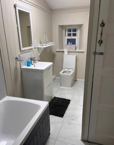 a bathroom with a tub and a toilet and a sink at Beautiful Countryside Cottage Alnwick in Alnwick