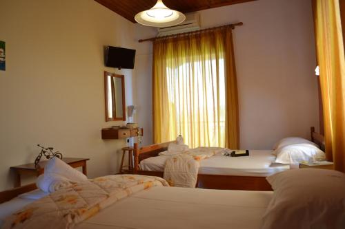 a hotel room with two beds and a window at Digenis Studios in Lygia