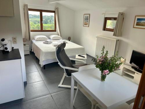 a room with a bed and a table and a kitchen at Studio Ittre in Ittre