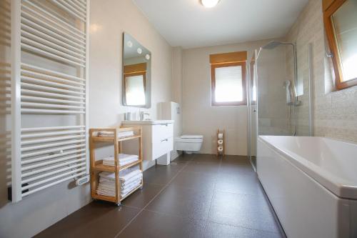 y baño con bañera, lavabo y aseo. en Apartments Poville Residence en Povile