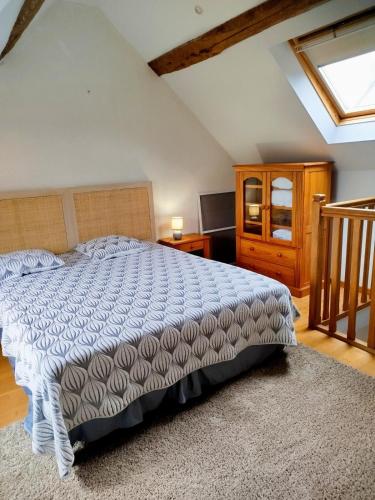 a bedroom with a large bed and a television at Petite parenthèse au gîte Layon in Les Garennes sur Loire