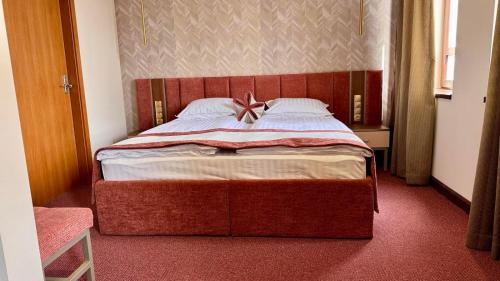 een slaapkamer met een groot bed met een boog erop bij Спа Хотел Орфей in Devin