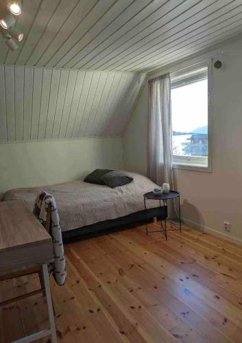 a bedroom with a bed and a window at Lofoten Seaside House in Offersøya