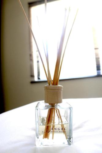 a glass vase with sticks in it on a table at Angel Guest House in Johannesburg