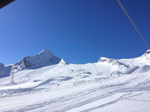 a snow covered slope with a mountain in the background at Haus Deutinger in Piesendorf