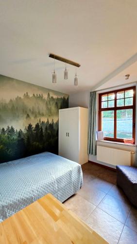 a bedroom with a bed and a painting on the wall at Apartamenty Józefina w willi Józefina in Szklarska Poręba