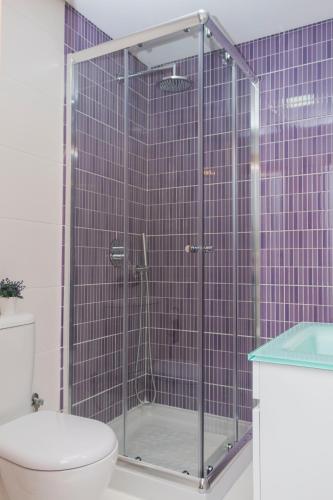 a glass shower in a bathroom with a toilet at Bracara Guest House "Arco" in Braga