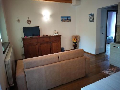 un soggiorno con un divano e una TV di Ai piedi del Monte Cimone a Fiumalbo