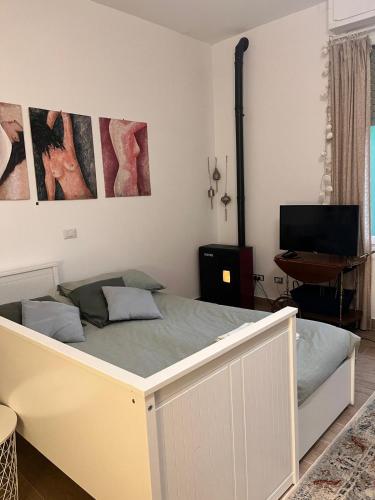 a white bed in a room with a desk at Monolocale Corbetta centro - House lab Milan in Corbetta
