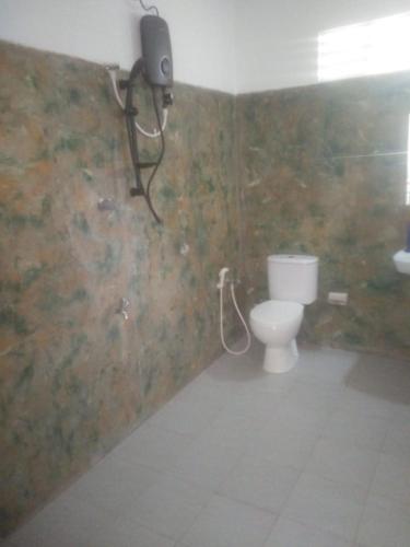 a bathroom with a toilet and a camera on the wall at Jayasri in Hikkaduwa