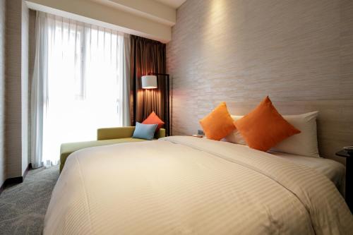 a hotel room with a large bed and a window at Via Hotel Taipei Station in Taipei