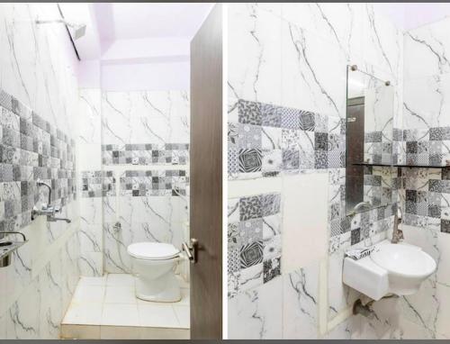a white bathroom with a toilet and a sink at Hotel Vanice Blue in Indore