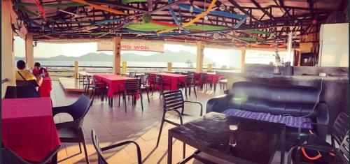 a restaurant with tables and chairs and a view of the ocean at Coron Sanho Pension in Coron