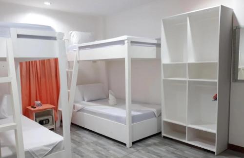 a room with two bunk beds and a desk at Coron Sanho Pension in Coron