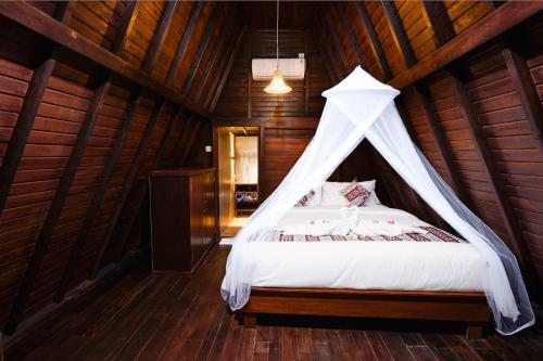 a bedroom with a canopy bed in a wooden room at Viyana Ubud Villas in Ubud