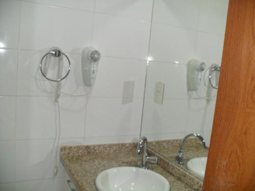 a bathroom with two sinks and a phone on the wall at Manaíra Palace Residence in João Pessoa