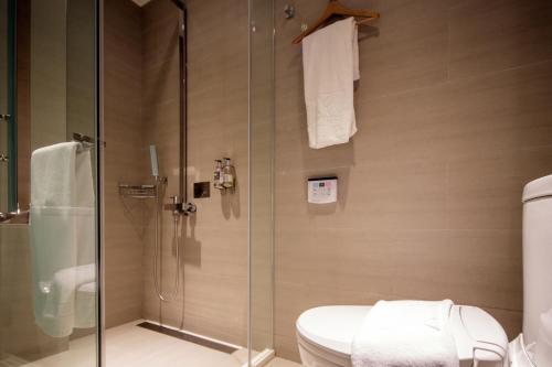 a bathroom with a toilet and a glass shower at Via Hotel Taipei Station in Taipei