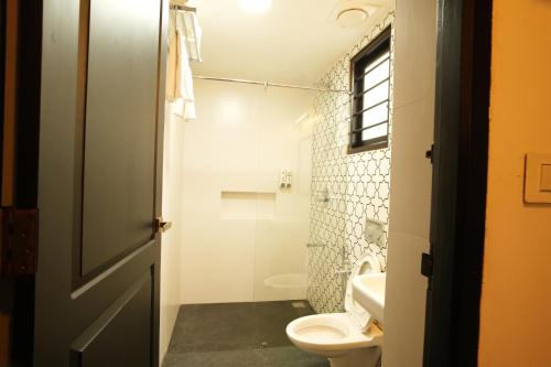 een badkamer met toilet en wastafel bij THE SUNSET BAY in Fort Kochi