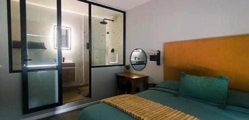 een slaapkamer met een bed met een spiegel en een douche bij NEW BOSTON in Bellville