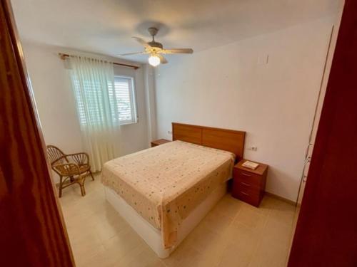 a bedroom with a bed and a ceiling fan at Apartamento en playa de Torrenostra in Torrenostra