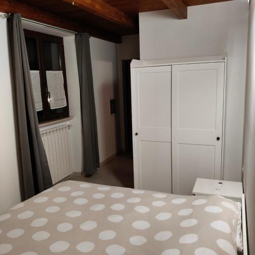 a bedroom with a bed and a cabinet and a window at Il Rifugio di Farinella in Putignano