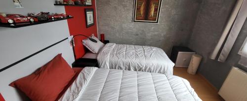 a bedroom with a white bed and red pillows at Mafadel in Cluny