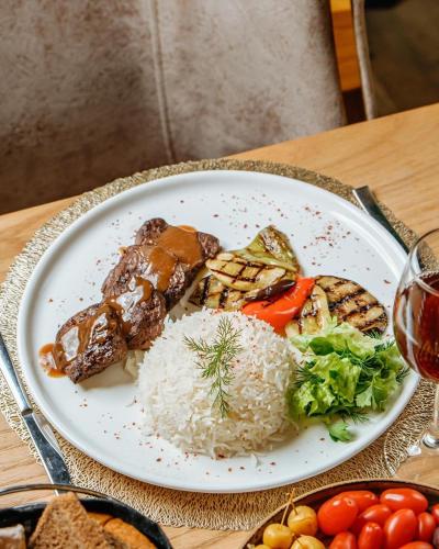 un piatto di cibo con riso e verdure su un tavolo di Krone Hotel & Restaurant a Baku