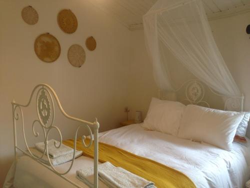 a bedroom with a white bed with a canopy at Cantinho Redondo Gerês in Entre Ambos os Rios