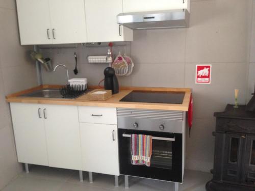 a small kitchen with a sink and a stove at Cantinho Redondo Gerês in Entre Ambos os Rios