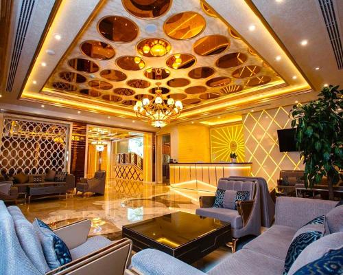 un soggiorno con divani e un soffitto con piastre di Krone Hotel & Restaurant a Baku