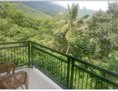 a balcony with a view of a palm tree at Winter Green Resorts, Munnar in Munnar