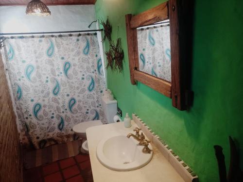 un bagno con lavandino, WC e finestra di Hostería Casa de Campo a Chascomús