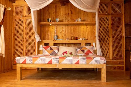 una camera da letto con un letto in una stanza con pareti in legno di Ocean zuri villa a Watamu