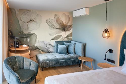una camera da letto con una sedia blu e un divano di Garden & SPA Hotel Das Götzfried a Ratisbona