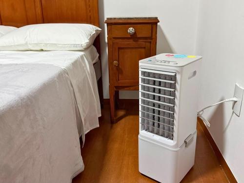 a room with a bed and a radiator next to a bed at Villa Ipe in Patos de Minas