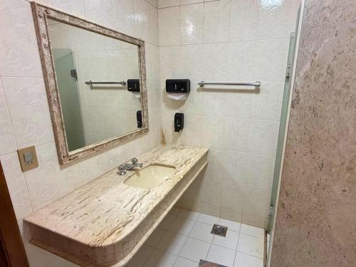 a bathroom with a sink and a mirror at Villa Ipe in Patos de Minas