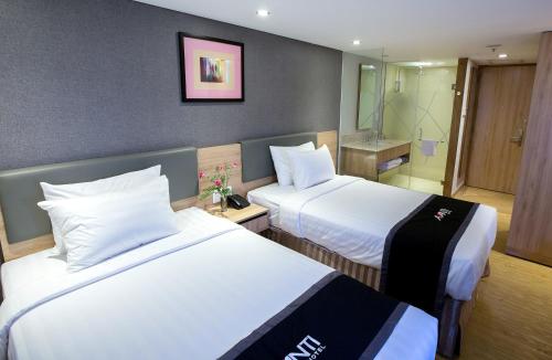 a hotel room with two beds and a bathroom at Avanti Hotel in Ho Chi Minh City