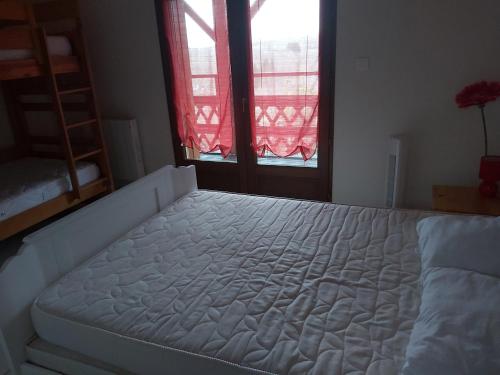 a large white bed in a room with a window at Gîte A l'orée des bois in Saint-Robert
