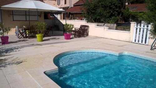 a swimming pool in the middle of a patio at Gîte A l'orée des bois in Saint-Robert
