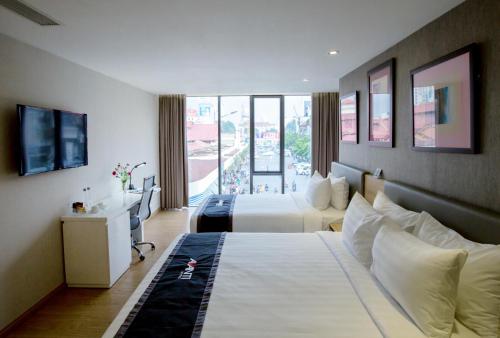 ein Hotelzimmer mit 2 Betten und einem Balkon in der Unterkunft Avanti Hotel in Ho-Chi-Minh-Stadt