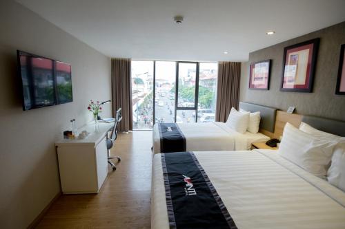 a hotel room with two beds and a window at Avanti Hotel in Ho Chi Minh City